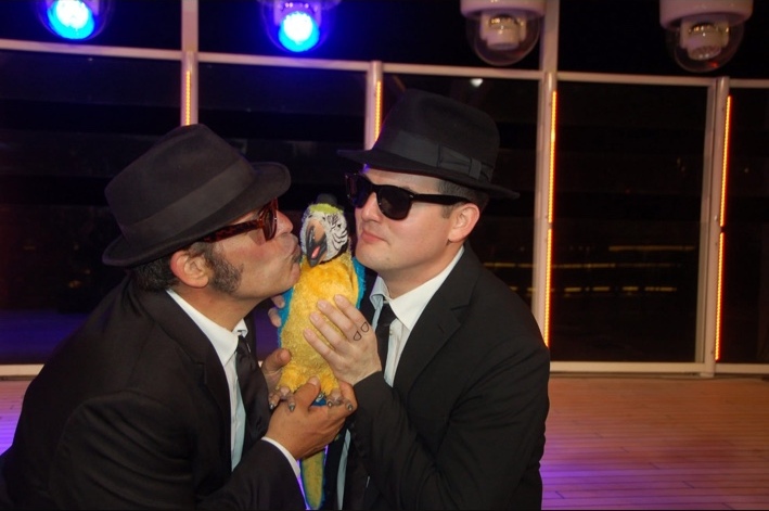 Robert Vicens and a fellow performer posing with a colorful parrot